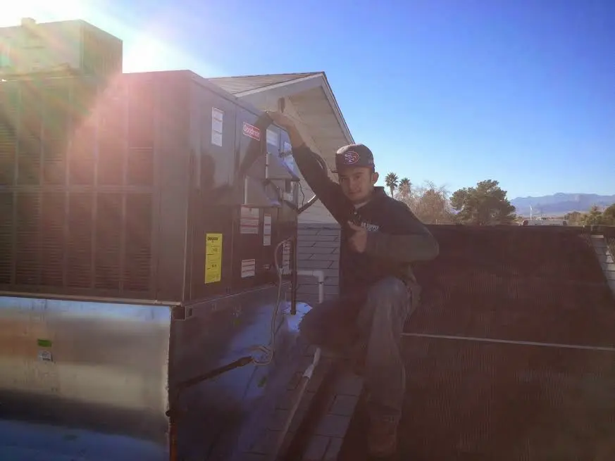 HVAC technician performing AC Tune-Up on a rooftop unit in Orono